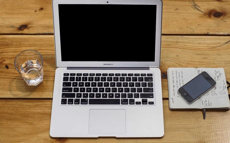 An overhead view of a laptop and notebook